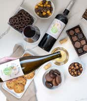 Alternative image 1 for A gift set with 2 bottles of wine - red and white, paired with chocolate pretzels, caramel popcorn, mini cookies, chocolate peanut butter buckeyes, six chocolate-covered Oreos, and a box assorted chocolates.