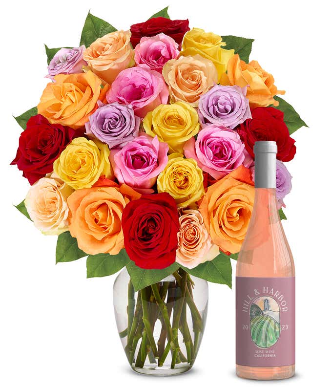 An exquisite bouquet of roses in a kaleidoscope of colorsvivid reds, soft pinks, warm oranges, sunny yellows, and gentle purplesarranged in a clear glass vase, accompanied by a sleek bottle of rose wine from California, 2023, embodying grace and festivi