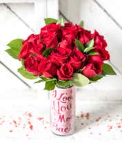 Alternative image 1 for a bouquet of 24 red roses with small white flowers and greenery in between in a clear glass vase