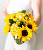 Alternative image 1 for A vibrant arrangement featuring yellow/orange bi-color roses, sunflowers, yellow button poms, yellow solidago, and bupleurum, optionally presented in a vase. This cheerful display brings a burst of sunshine and joy to any occasion.