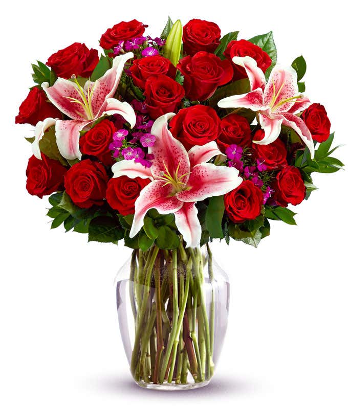 18 red roses, Stargazer lilies, pink dianthus, floral greens, optional glass vase.