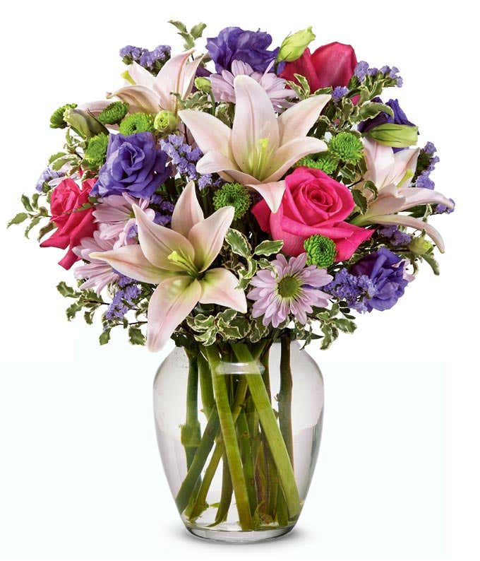 Pink Asiatic lilies, pink roses and purple flowers in a vase