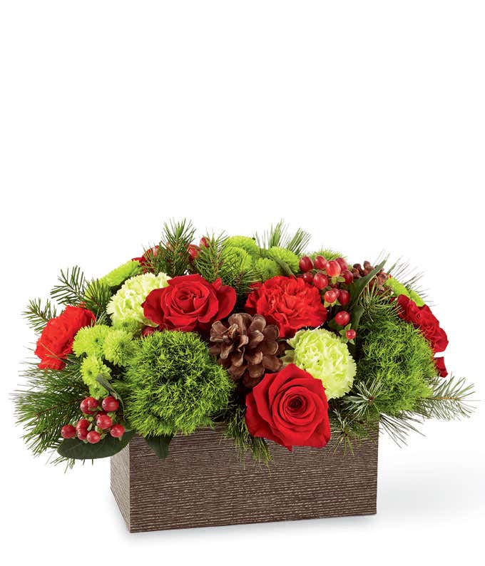 Red roses in a rectangle vase with hypericum berries for a Christmas bouquet