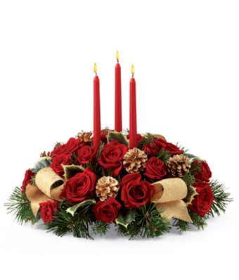 Red roses, pink and winter greens in a centerpiece with candles