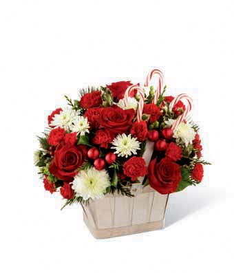 Red roses, red carnations and candy canes in a woven basket