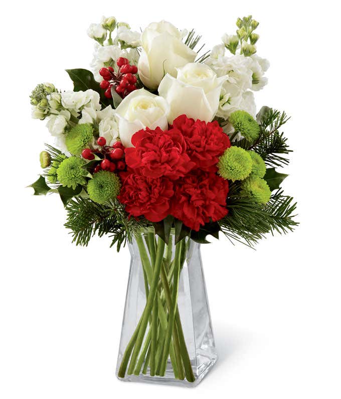 White roses, red carnations, and green poms Christmas flowers bouquet in a vase