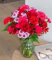 Alternative image 1 for Round, full, bouquet of red and hot pink flowers, in a clear vase