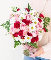 Alternative image 4 for A delightful arrangement featuring hot pink spray roses, white traditional daisies, and pink mini carnations, beautifully arranged in a clear vase with a pink bow. This vibrant mix offers a cheerful and elegant display.