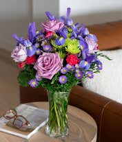 Alternative image 1 for Tall arrangement of purple roses, iris, and green and purple asters, all in a cylinder vase