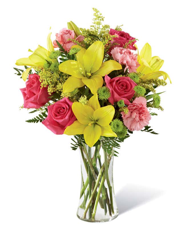 Tall arrangement with pink roses, yellow lilies in a tall cylinder vase