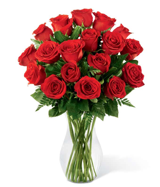 18 long-term red roses with fresh floral greens in a tall clear glass vase