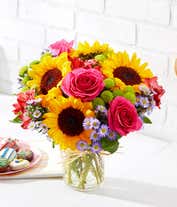 Alternative image 3 for Floral arrangement featuring sunflowers, red alstroemeria, pink roses (in deluxe and premium versions), purple monte casino, and green button poms in a mason jar vase, with a personalized card message.