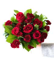 Alternative image 3 for A striking arrangement featuring red roses, red mini carnations, and salal, elegantly presented in a red gathering vase. This bold and vibrant display is perfect for adding a touch of elegance and passion to any occasion.