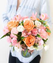 Alternative image 1 for A delightful floral arrangement of peach roses, pink carnations, pink alstroemeria, and white lisianthus, elegantly arranged in a glass vase. This soft and romantic mix of flowers offers a gentle and inviting display.