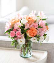 Alternative image 3 for A delightful floral arrangement of peach roses, pink carnations, pink alstroemeria, and white lisianthus, elegantly arranged in a glass vase. This soft and romantic mix of flowers offers a gentle and inviting display.