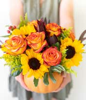 Alternative image 3 for  A cheerful floral arrangement featuring sunflowers, orange roses, safari sunset, red berries, and yellow solidago, all beautifully arranged in a pumpkin container.