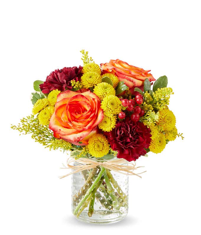 Yellow and orange daisies in pumpkin container