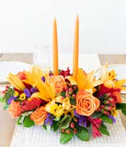 Alternative image 3 for Fall centerpiece with orange candles, orange lilies, roses, yellow poms, purple statice, and red hypericum berries.
