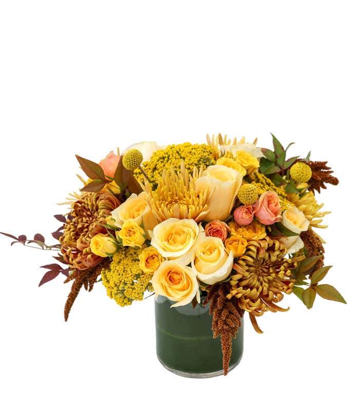 Short leaf lined vase with Yellow, Cream, Bronze, and Peach Flowers