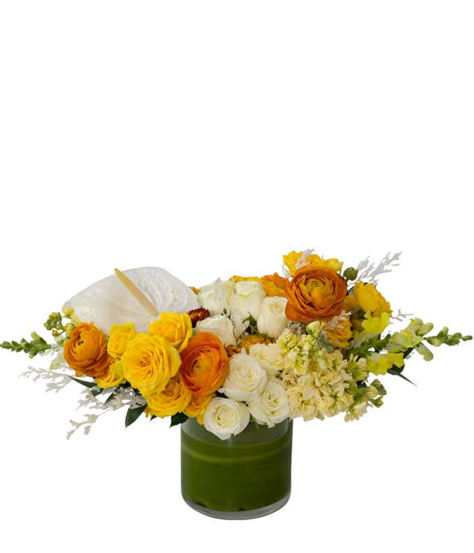 Low and lush asymmetrical garden style design of all yellow, orange, cream, and white flowers