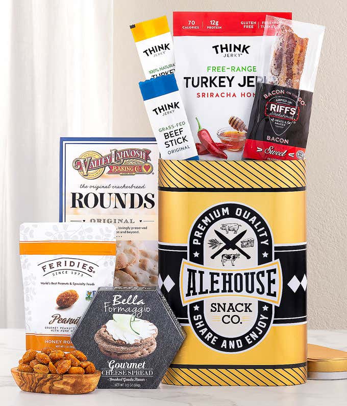 This Alehouse-themed gift tin features a sleek black and yellow design filled with gourmet snacks. It includes Think Jerky's Turkey Jerky and Beef Sticks, Riffs Bacon, Valley Lahvosh crackers, Feridies Peanuts, and Bella Formaggio Cheese Spread. ​&#