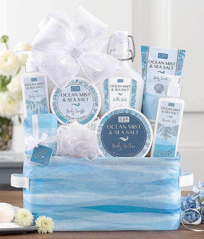 Ocean Mist & Sea Salt gift set displayed in a blue and white patterned basket, featuring body lotion, body butter, shower gel, bath salts, a body souffl, and a mesh sponge