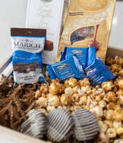 Alternative image 4 for A gourmet gift basket with assorted chocolates and treats, including Lindt Lindor truffles, Marich dark chocolate sea salt caramels, French truffles, Ghirardelli dark chocolate sea salt caramel squares, chocolate-covered cookies, caramel popcorn, and more