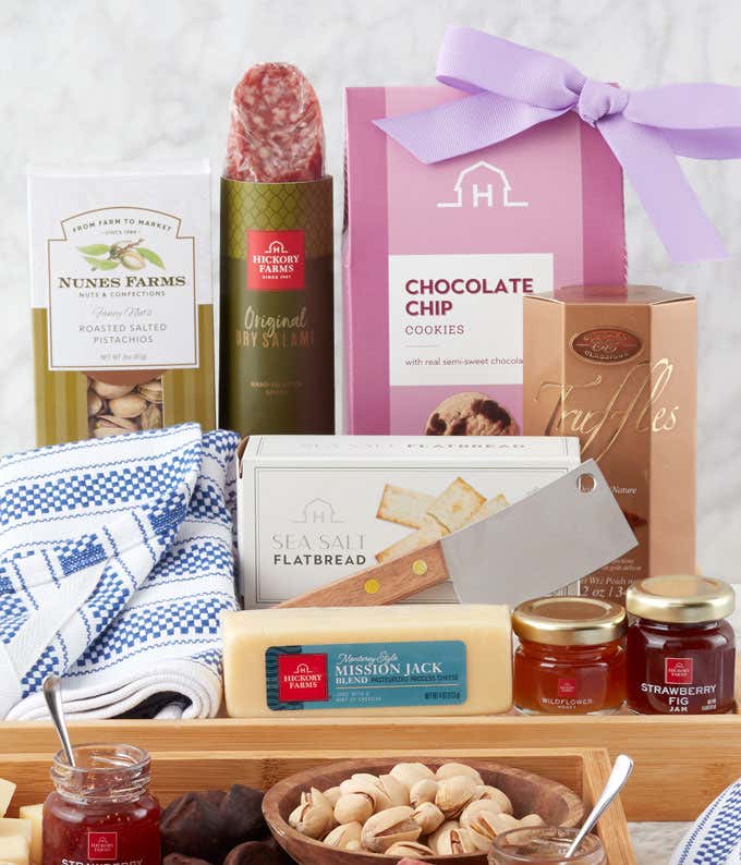 A Mother's Day gift tray filled with gourmet treats including Original Dry Salami, Mission Jack Blend cheese, Sea Salt Flatbread, Strawberry Fig Jam, Wildflower Honey, Chocolate Chip Cookies, Roasted Salted Pistachios, and French Truffles, presented on a 