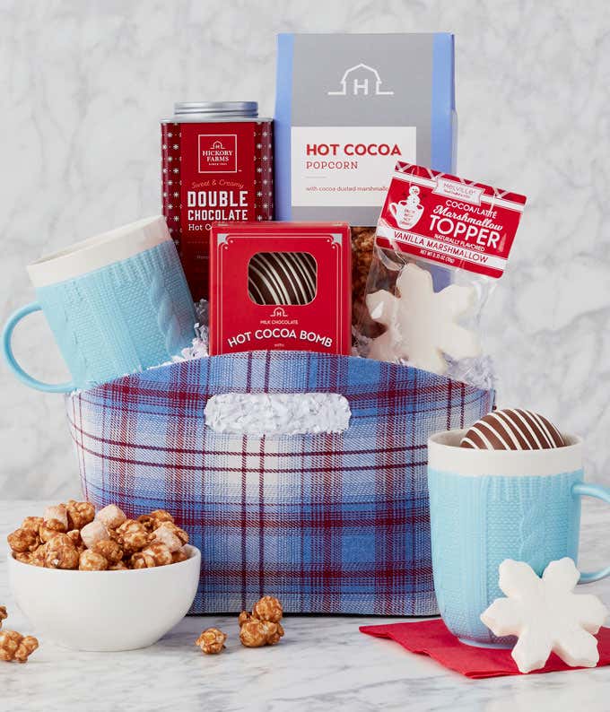 A cozy gift set featuring Double Chocolate Hot Cocoa Mix, a Milk Chocolate Hot Cocoa Bomb, a Snowflake Marshmallow Topper, Hot Cocoa Popcorn, and a Blue Sweater Mug, perfect for enjoying a warm, chocolatey treat.