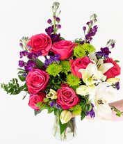Alternative image 2 for Dark pink roses, white Asiatic lilies, lavender stock, green button spray chrysanthemums, lavender sinuata statice, sword fern, huckleberry in a cylinder vase.