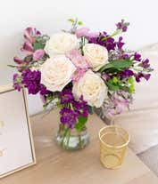 Alternative image 4 for A sophisticated floral arrangement featuring crème roses, lavender alstroemeria, purple stock, purple button chrysanthemums, lavender cushion spray chrysanthemums, white limonium, bupleurum, and huckleberry, all elegantly arranged in a cylinder vase.