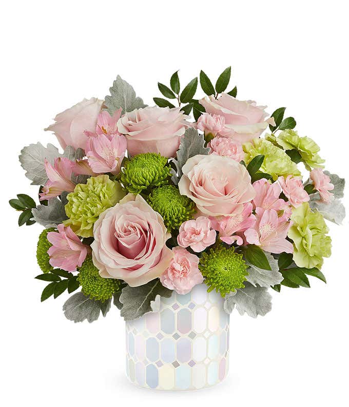 Image of a Mother's Day arrangement featuring Light Pink Roses, Light Pink Alstroemeria, Green Carnations, Miniature Light Pink Carnations, and floral greenery, presented in a keepsake iridescent mosaic vase.