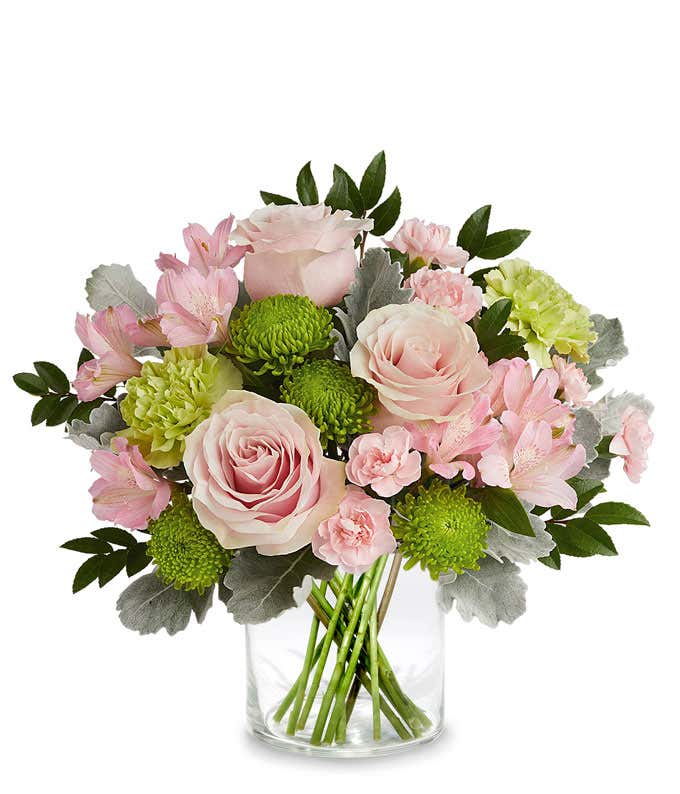 Image of a Mother's Day arrangement featuring Light Pink Roses, Light Pink Alstroemeria, Green Carnations, Miniature Light Pink Carnations, and floral greenery, presented in a keepsake iridescent mosaic vase.