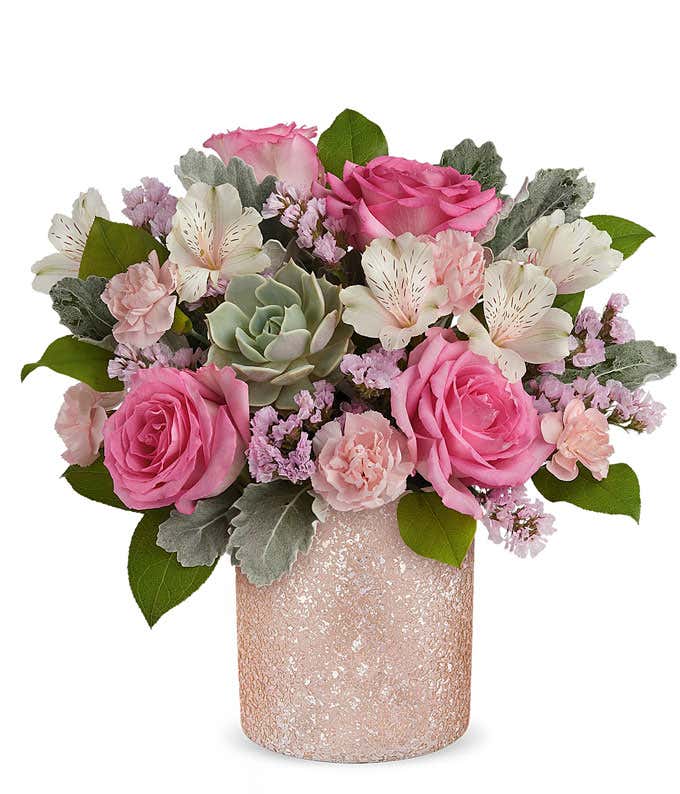 Image of a Mother's Day arrangement featuring Pink Roses, Ivory Alstroemeria, Pink Miniature Carnations, Echeveria Succulent, Pink Sinuata Statice, and floral greenery, presented in a keepsake Pink Shimmer Vase.