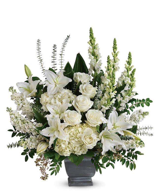 Funeral Arrangement: White hydrangeas, roses, snapdragons, stock flowers, and floral greenery in a Grey Modern Heritage Pot, symbolizing serenity and grace.