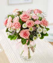 Alternative image 4 for Floral arrangement featuring pink roses, white roses, mini carnations, and green poms in a clear glass vase with a bow.