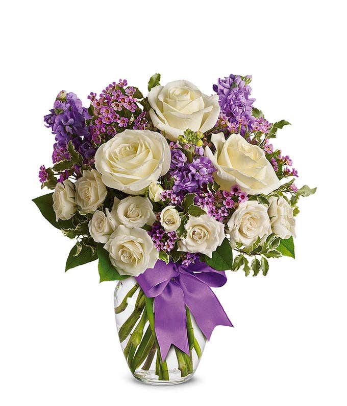 White roses and purple stock in a vase