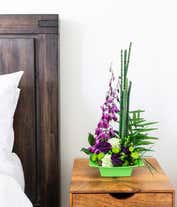 Alternative image 3 for A striking arrangement featuring purple dendrobium orchids, green carnations, hypericum, and bamboo-like equisetum. This unique and vibrant display offers a touch of exotic elegance to any setting. 