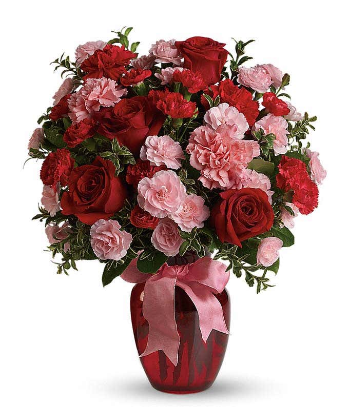 Red roses, pink carnations in a red vase for a romantic bouquet