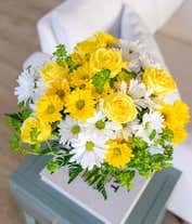 Alternative image 2 for A cheerful arrangement featuring white daisy spray chrysanthemums, yellow daisy spray chrysanthemums, and assorted greens, all elegantly presented in a clear vase. This bright and fresh display is perfect for adding a touch of sunshine to any space.
