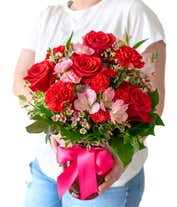 Alternative image 2 for A striking arrangement featuring red roses, pink alstroemeria, red carnations, and pink waxflower, elegantly presented in a red vase with a ribbon. This bold mix offers a stunning and romantic display.