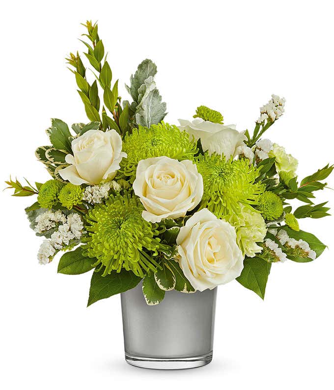  White Roses, Green Carnations, and Chrysanthemums in a Silver Glass Cylinder Vase, accented with Floral Greens.