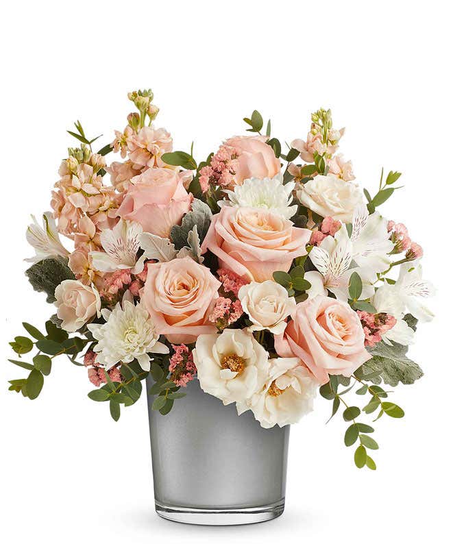 Elegant floral arrangement with soft pink roses, white roses, white chrysanthemums, pink stock, and white alstroemeria in a sleek silver vase, perfect gift for loved ones.