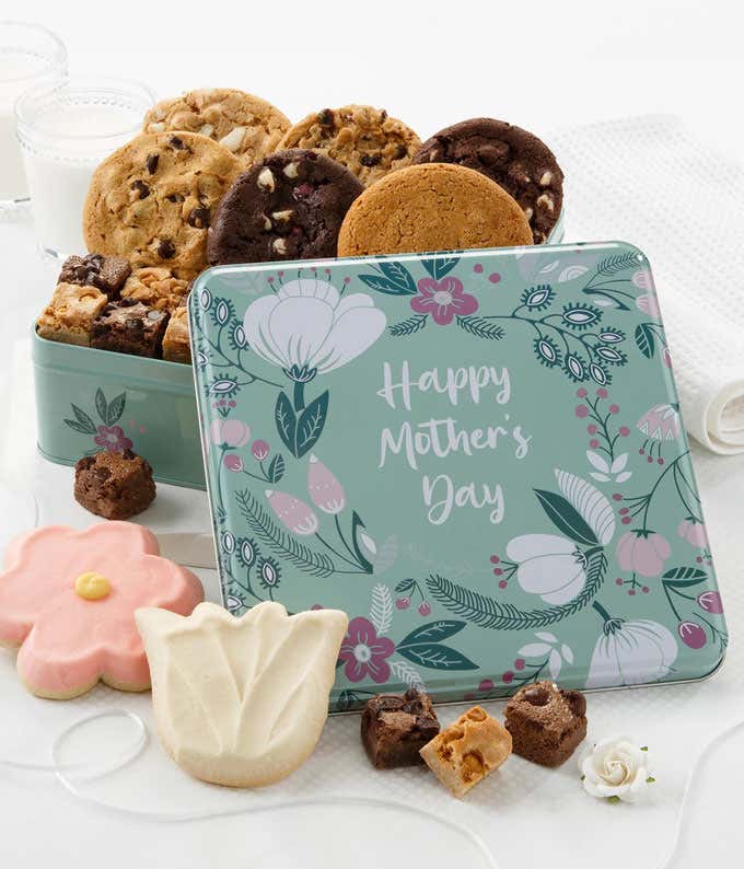 A colorful tin filled with Mrs. Fields cookies and brownie bites, featuring assorted flavors including chocolate chip, oatmeal raisin, and dark chocolate raspberry, along with two frosted cookies in a 
