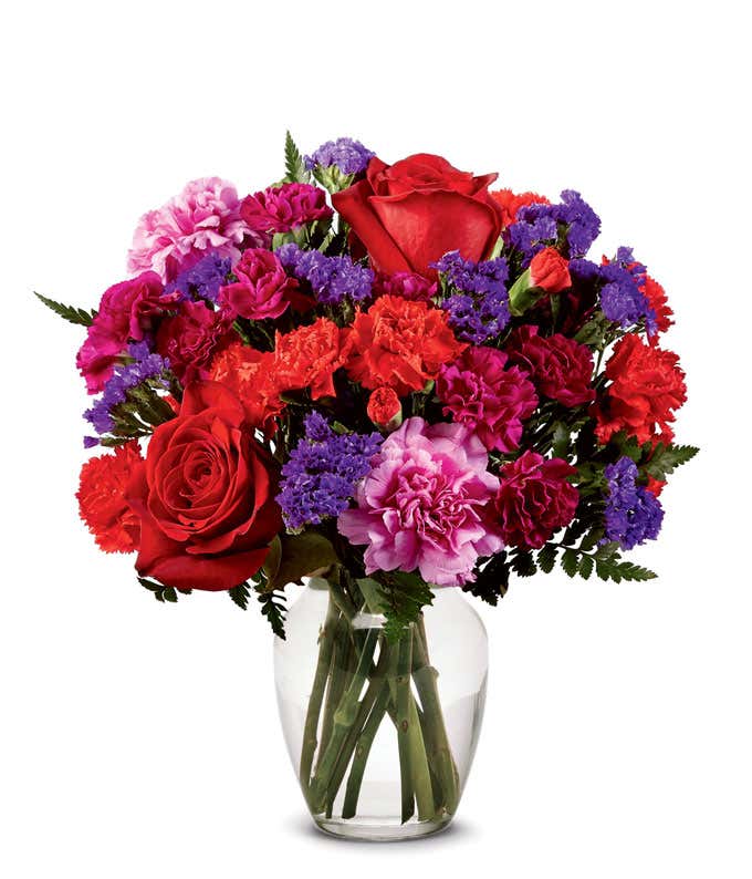 Red rose and hot pink carnations in clear glass vase