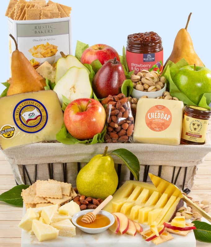 A gift basket filled with fresh pears, apples, farmstead cheddar, Vella Romanello cheese, roasted salted almonds, pistachios, flatbread bites, strawberry and fig jam, and a jar of California wildflower honey, perfect for gifting and gourmet enjoyment.