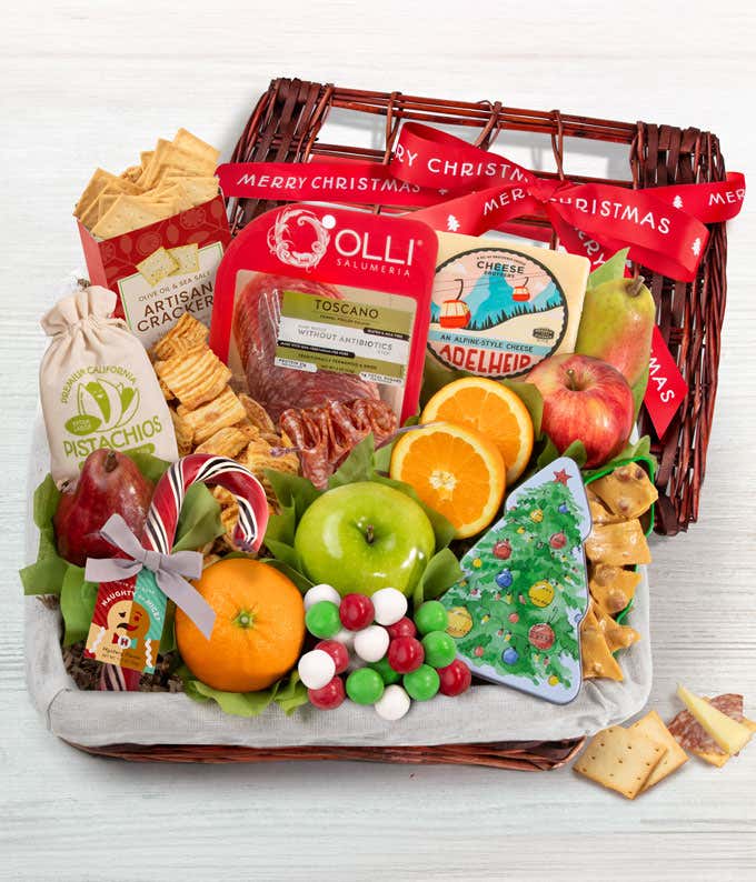 A wicker basket with artisan crackers, gourmet salami and cheese, peanut brittle, mustard, pistachios, fresh fruits like apples, pears, oranges, and an ornament-shaped cookie. A seasonal red bow completes the look, perfect for holiday gifting.