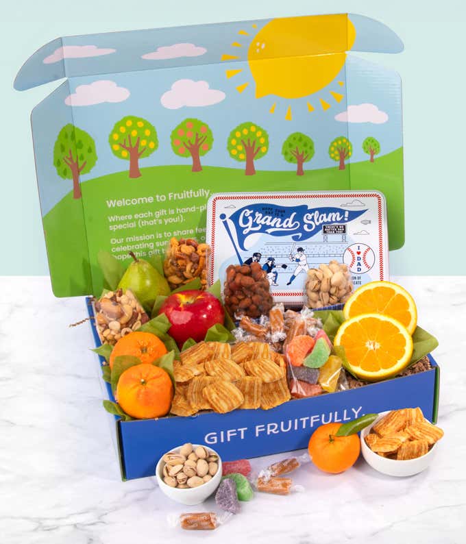 Baseball-themed snack gift box featuring fresh fruit including apples, pears, oranges, and mandarins, along with pistachios, snack mix, gummy candies, and cheese crisps, displayed in a blue Gift Fruitfully box with a colorful nature-themed lid.