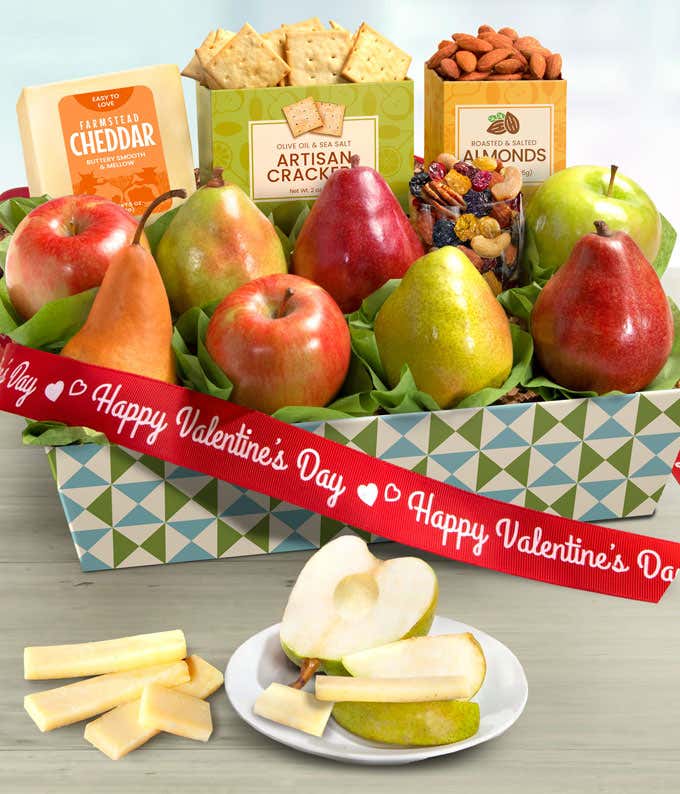 Valentine’s Day fruit and gourmet gift basket with red and green apples, pears, farmstead cheddar cheese, artisan crackers, roasted almonds, and snack mix in a patterned keepsake box with red Valentine’s ribbon.