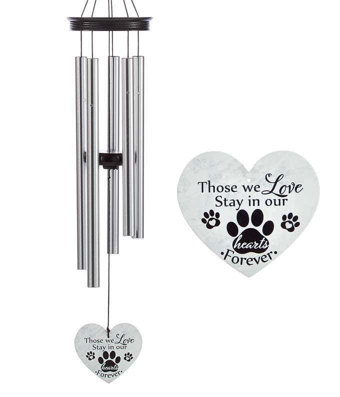 A windchime with metal rods and a wooden accents and heart shaped sail. White sail reads those we love stay in our hearts forever with black hearts and pawprints.